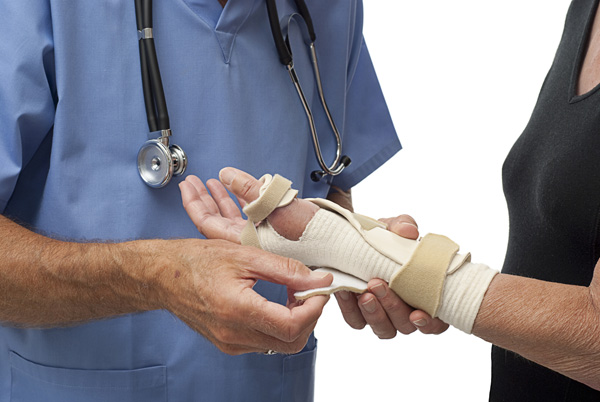 Doctor fitting splint on woman's wrist