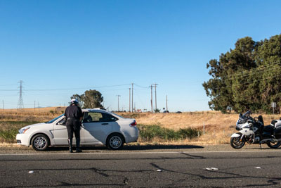 Police officer giving ticket to pulled over driver