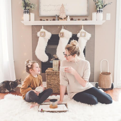 Mother and daughter in front of fireplace with stockings